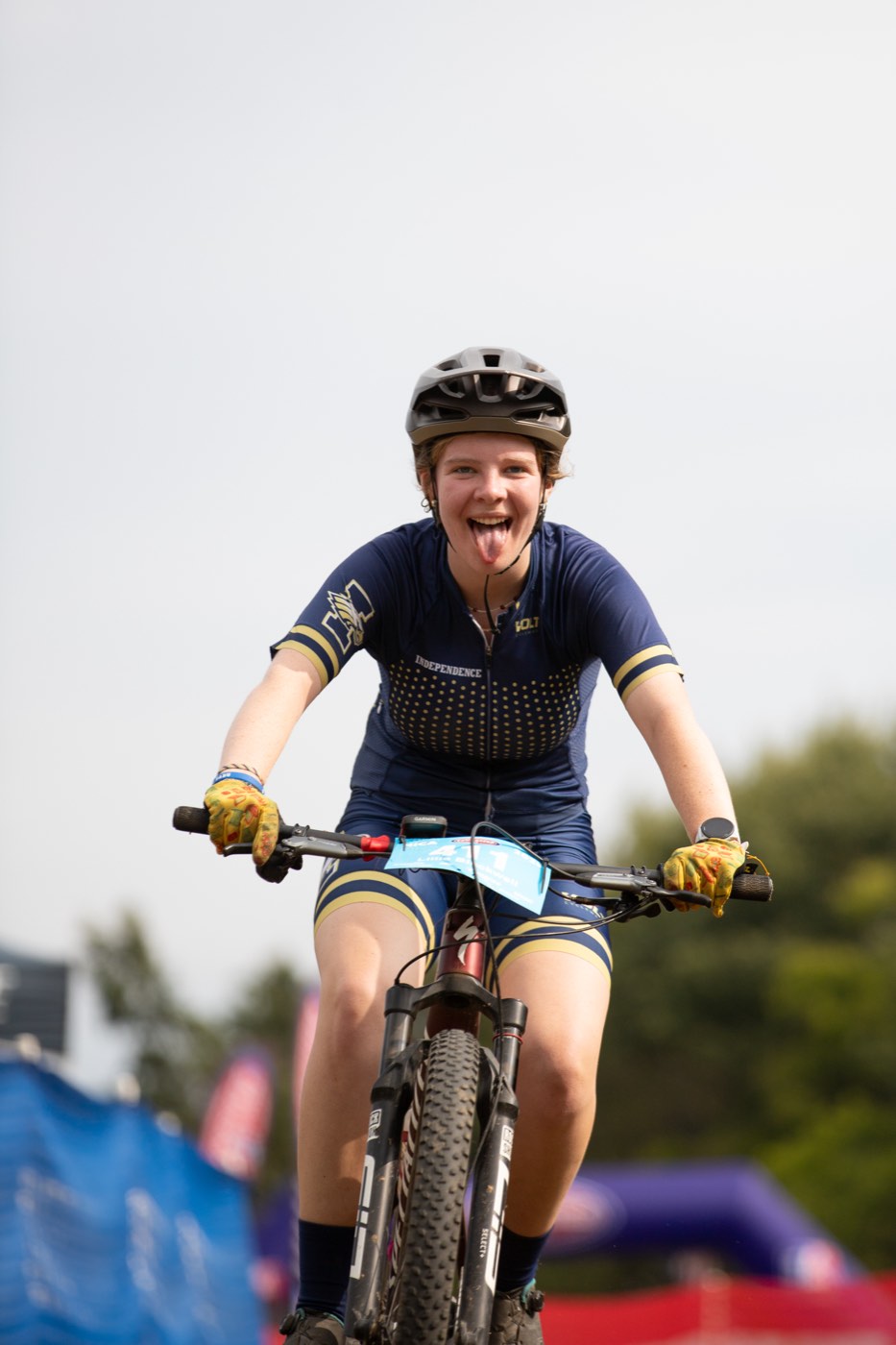 Rider crossing the finish with her tongue out