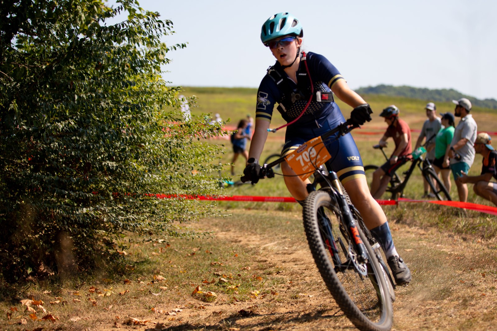 Rider railing a corner mid-race with spectators behind